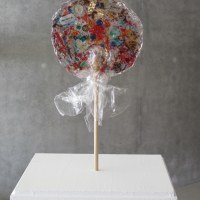 , Sucette plexiglas et matériaux divers incrustés, de dia :30 cm, h 2cm 